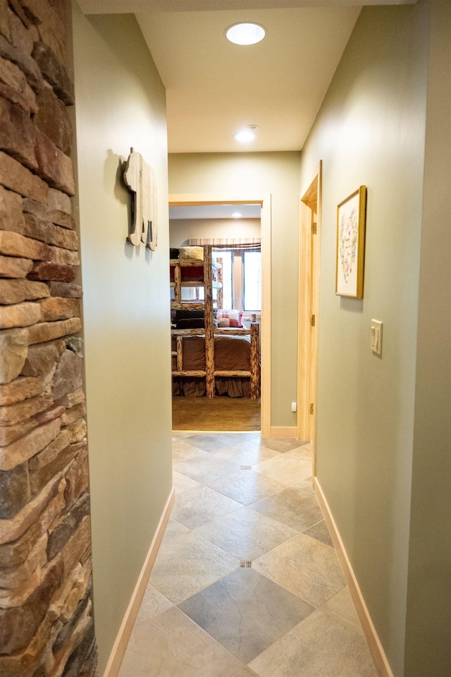 hall featuring recessed lighting and baseboards