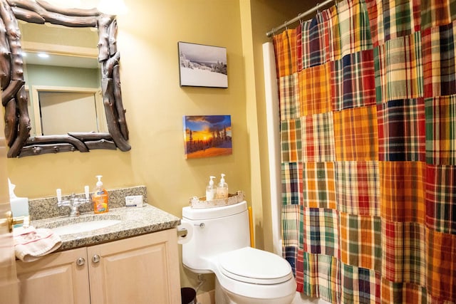 full bath featuring toilet, a shower with shower curtain, and vanity