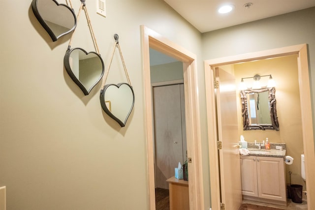 hall featuring a sink and recessed lighting