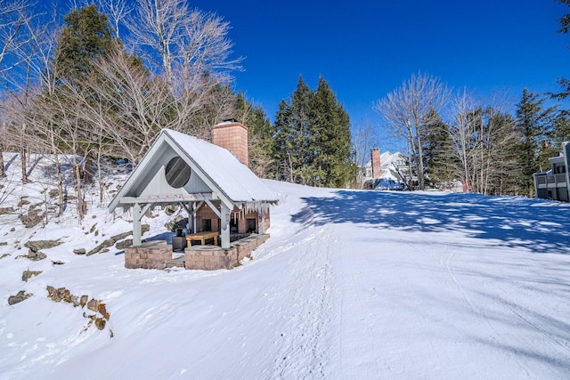 snow covered property with a chimney