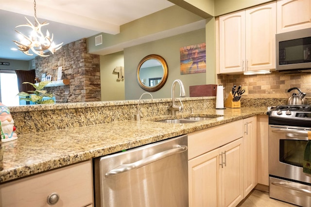 kitchen featuring light stone counters, stainless steel appliances, decorative backsplash, a sink, and beamed ceiling