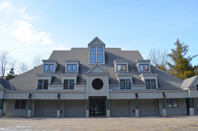 view of front facade featuring a garage, roof with shingles, and board and batten siding