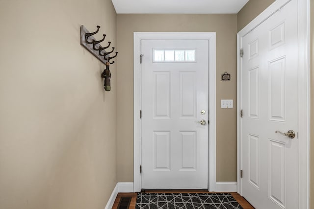 doorway to outside with dark wood-style floors, visible vents, and baseboards