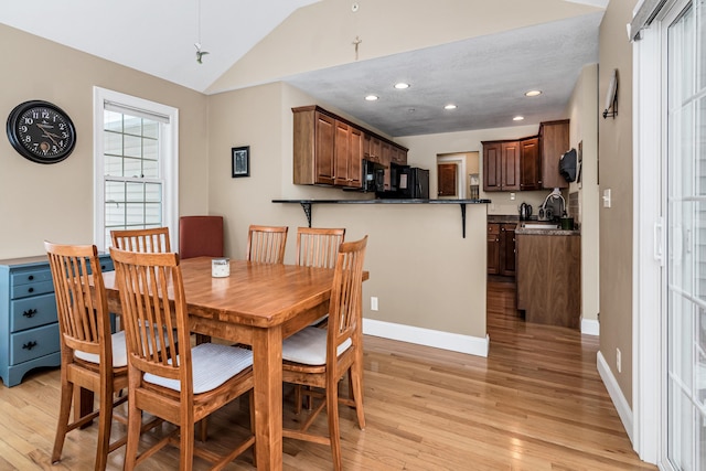 dining space with recessed lighting, light wood-style flooring, baseboards, and lofted ceiling