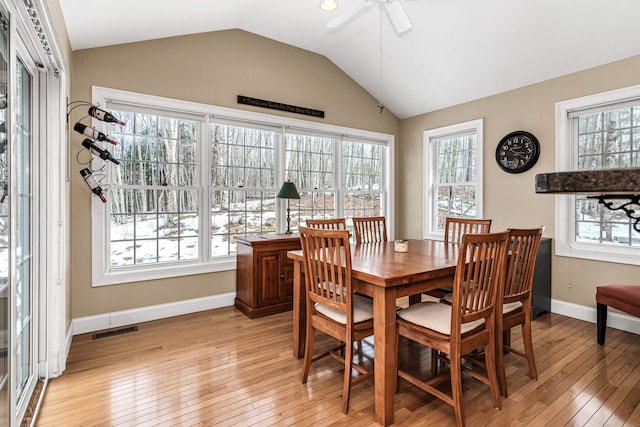 dining room featuring visible vents, baseboards, light wood-style floors, lofted ceiling, and ceiling fan