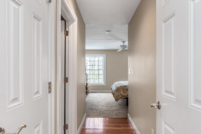 hallway with wood finished floors and baseboards