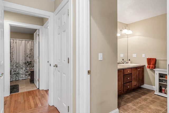 full bathroom with tile patterned floors, vanity, and baseboards