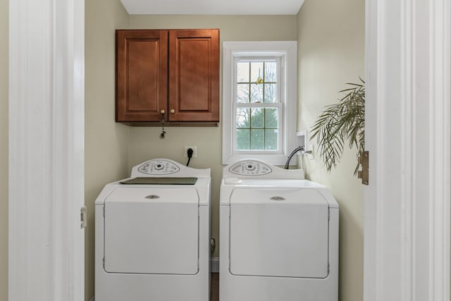 washroom featuring washer and clothes dryer and cabinet space