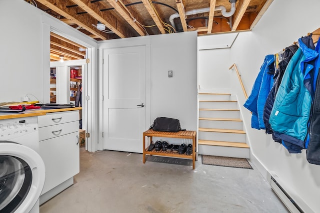 clothes washing area with washer / clothes dryer, baseboard heating, and laundry area