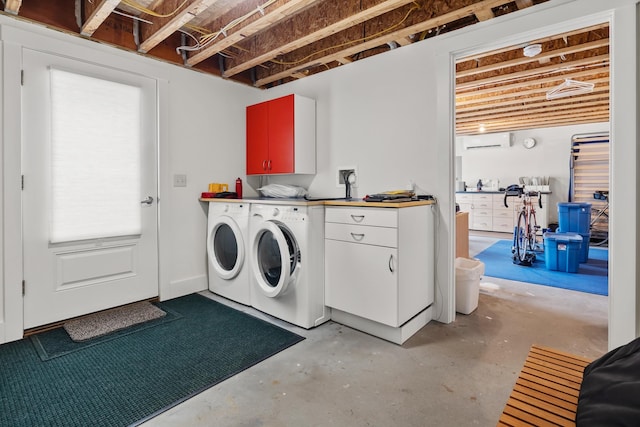 washroom featuring washer and dryer, cabinet space, and a wall mounted AC