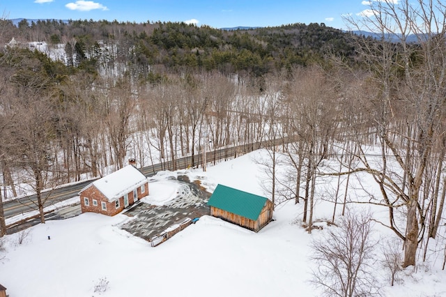 snowy aerial view featuring a forest view