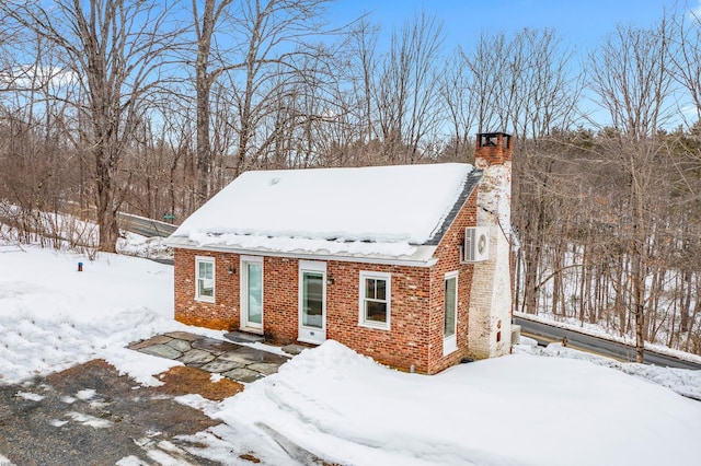 view of front facade featuring brick siding and a chimney