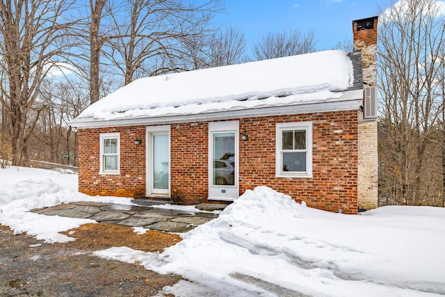 view of front of property featuring brick siding and a chimney