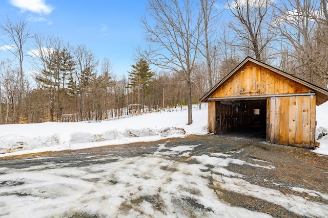 snow covered garage with a detached garage