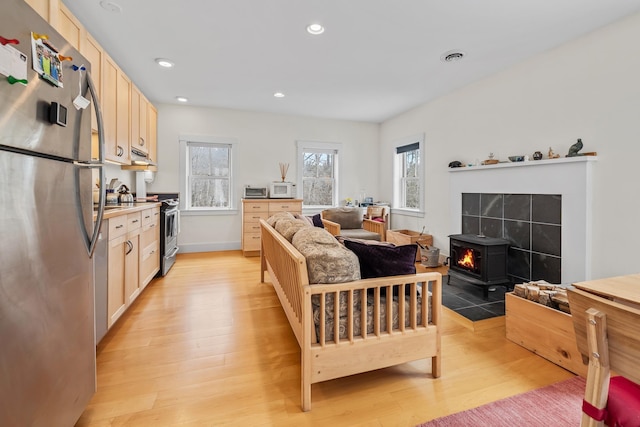 kitchen with light wood-type flooring, stainless steel appliances, a wealth of natural light, and light brown cabinetry