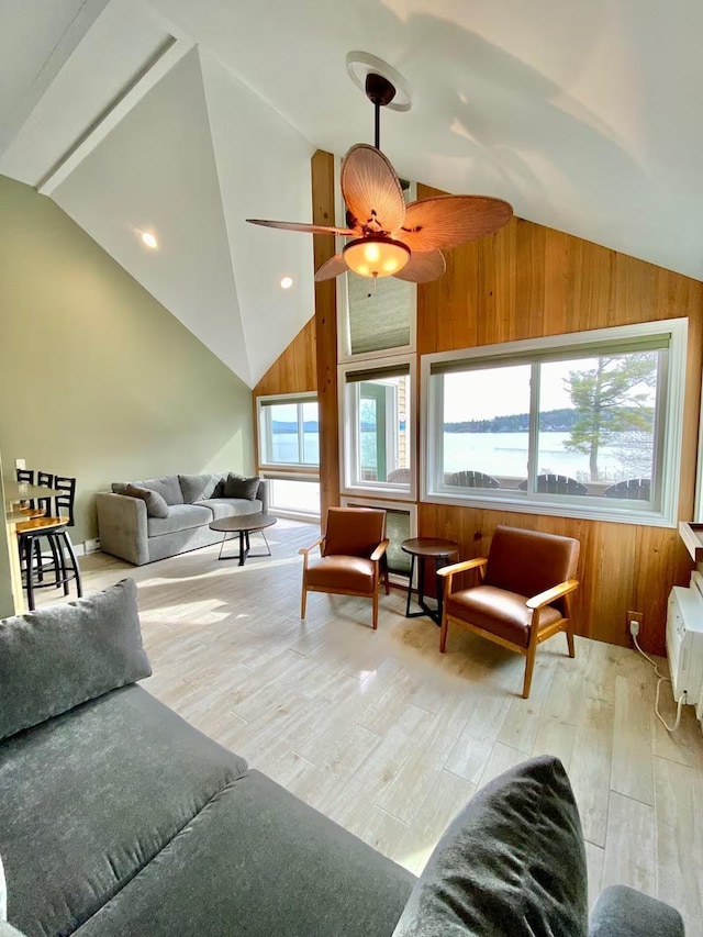 living room featuring lofted ceiling, plenty of natural light, and wooden walls