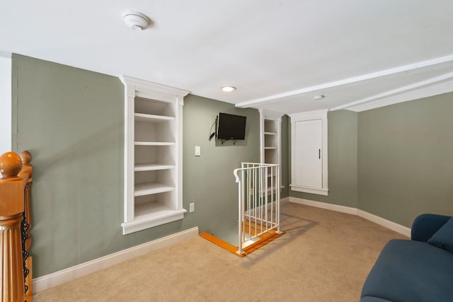 sitting room with carpet, built in shelves, baseboards, and an upstairs landing