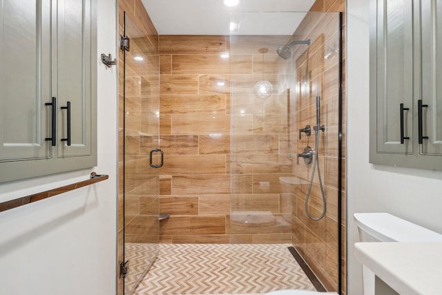 bathroom featuring a shower stall, toilet, and vanity