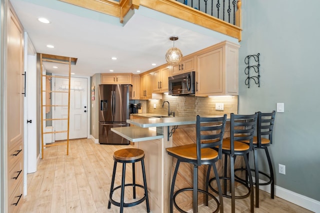 kitchen with tasteful backsplash, stainless steel fridge with ice dispenser, a peninsula, light wood-type flooring, and a sink