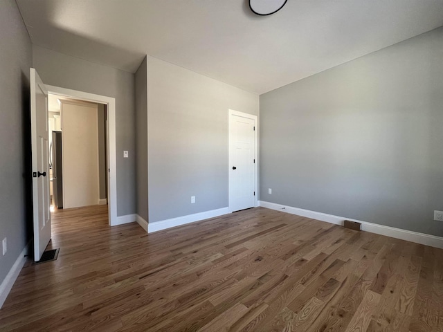 unfurnished bedroom with baseboards and wood finished floors