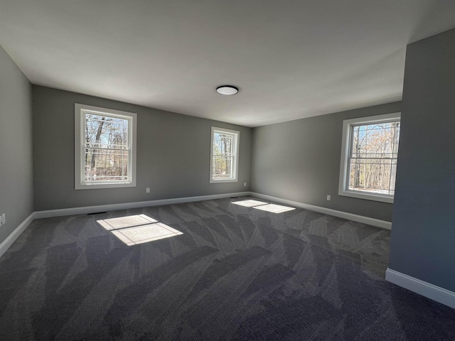 spare room featuring carpet and baseboards