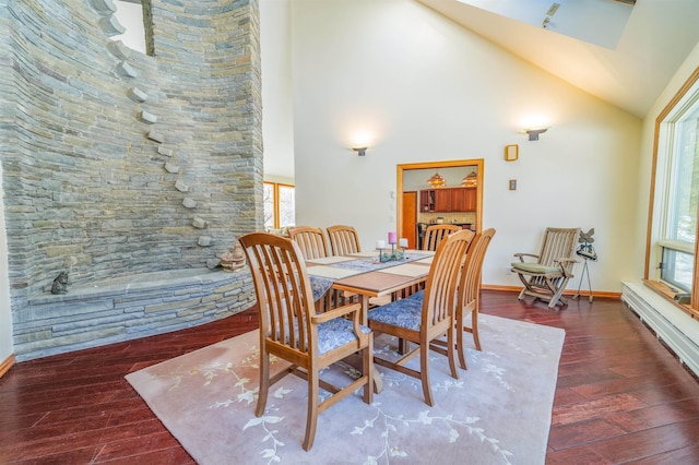 dining area with high vaulted ceiling, wood finished floors, and baseboards