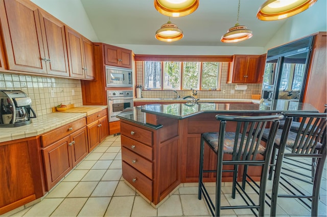 kitchen with stainless steel appliances, lofted ceiling, a sink, and decorative backsplash