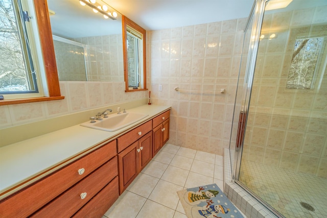 full bathroom with vanity, a shower stall, tile walls, and tile patterned floors