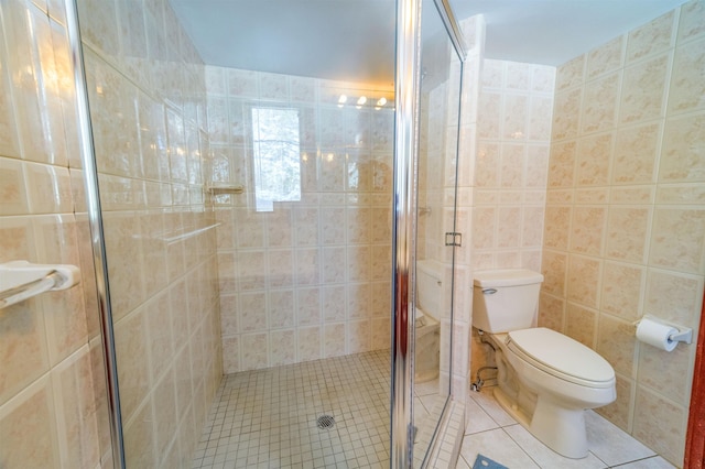 bathroom featuring tile walls, tile patterned flooring, toilet, and a shower stall