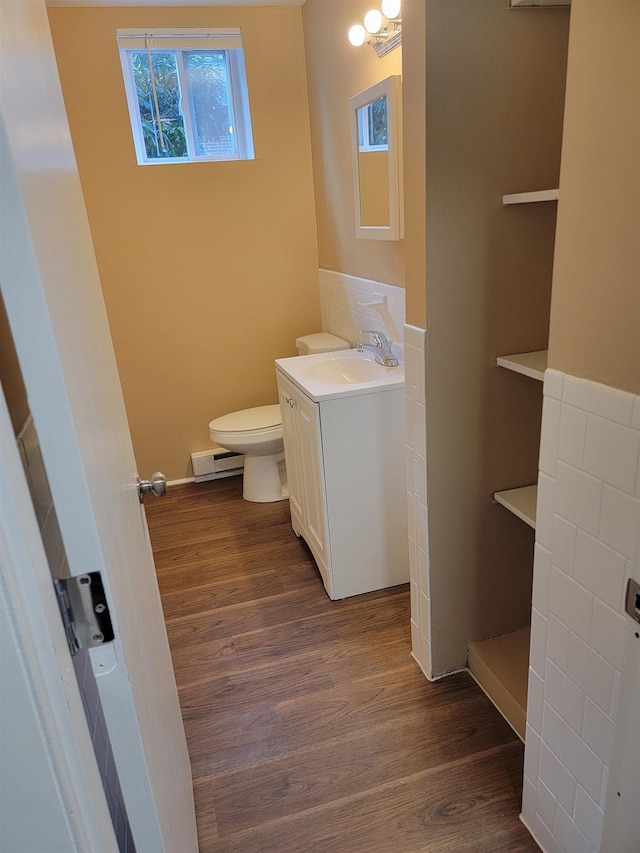 bathroom featuring a baseboard radiator, vanity, toilet, and wood finished floors