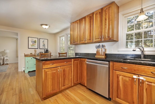 kitchen featuring a sink, a peninsula, brown cabinetry, and dishwasher