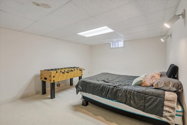 bedroom with carpet floors, a paneled ceiling, and baseboards