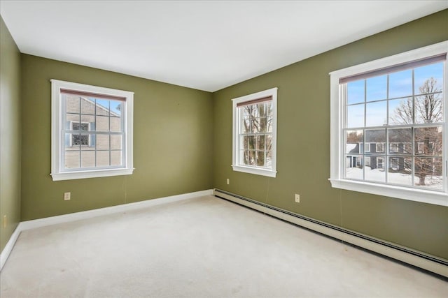 carpeted spare room featuring baseboard heating and baseboards