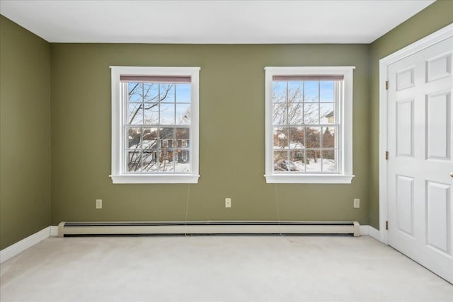 empty room with baseboards, baseboard heating, carpet, and a healthy amount of sunlight