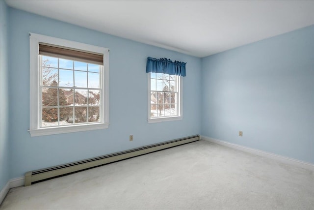 spare room with carpet floors, baseboards, and a baseboard heating unit