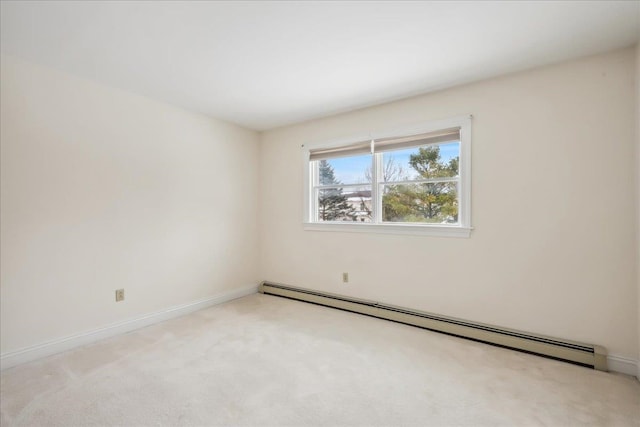 unfurnished room featuring a baseboard heating unit, light colored carpet, and baseboards