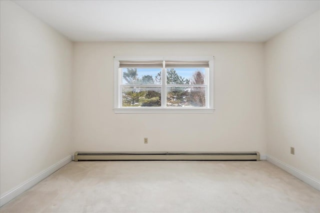 carpeted spare room with a baseboard radiator and baseboards