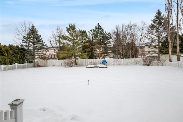 snowy yard featuring a fenced backyard