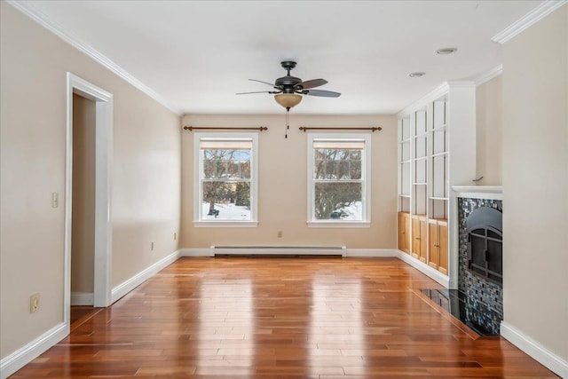 unfurnished living room featuring baseboards, a tile fireplace, a baseboard radiator, wood finished floors, and crown molding