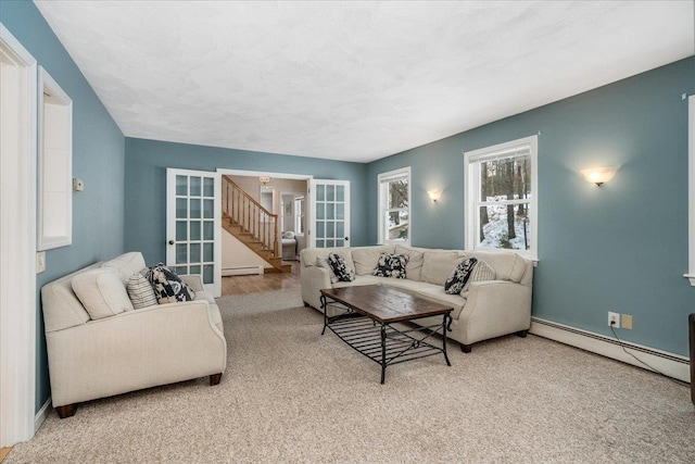 living area featuring a baseboard heating unit, french doors, baseboards, and stairs