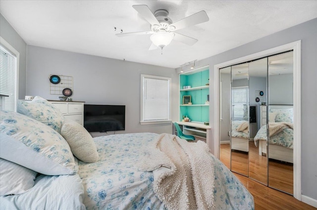 bedroom featuring ceiling fan, a closet, baseboards, and wood finished floors