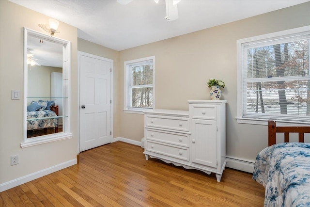 bedroom featuring multiple windows, light wood-style flooring, and baseboards