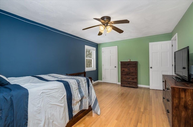 bedroom with wood-type flooring, ceiling fan, and baseboards