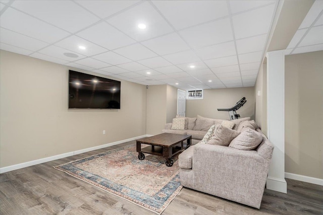 living room with baseboards, a drop ceiling, wood finished floors, and recessed lighting