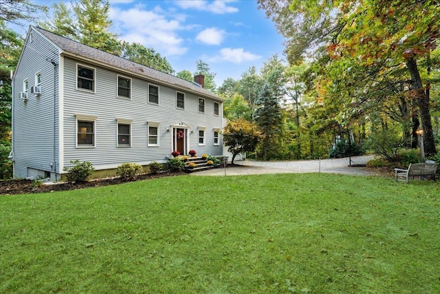 view of front facade with a chimney and a front lawn