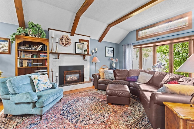 living room with lofted ceiling with beams, a textured ceiling, a brick fireplace, and wood finished floors