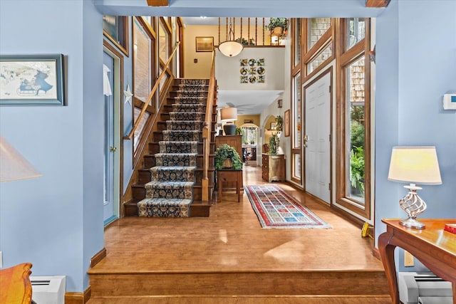 entryway featuring stairs, a high ceiling, and wood finished floors