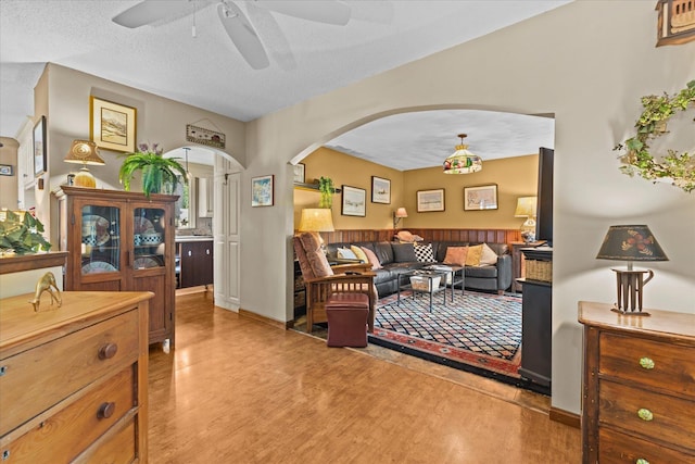 bedroom featuring arched walkways, a textured ceiling, and wood finished floors