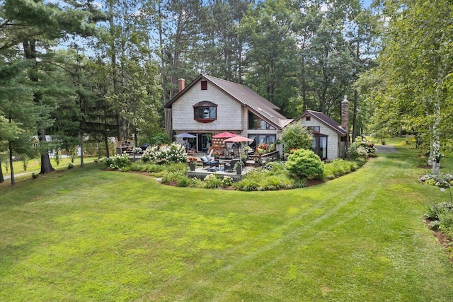 rear view of property with a lawn and a chimney