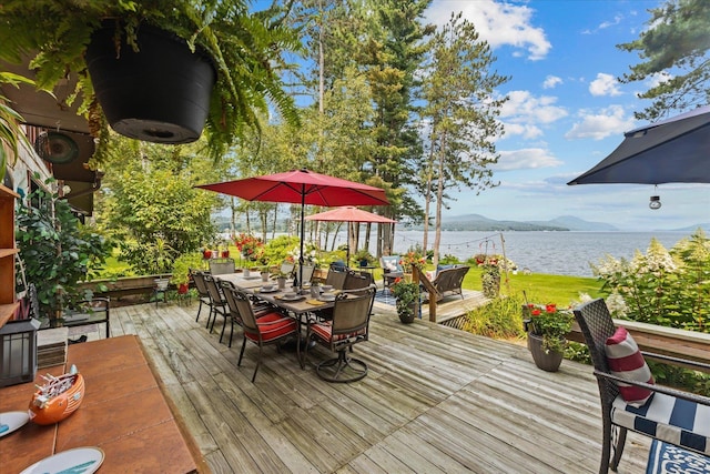 deck featuring outdoor dining area and a water and mountain view